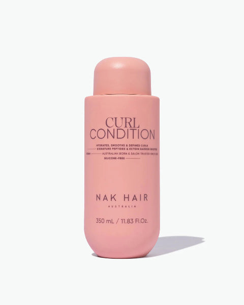Pink bottle of NAK Hair Curl Conditioner on a white background