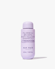 Purple shampoo bottle labeled 'Platinum Blonde Anti-Yellow Shampoo' by Nak Hair on a white background
