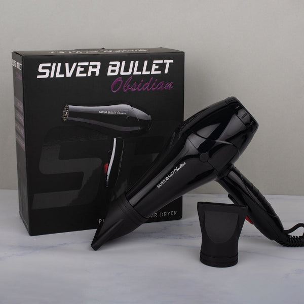Black hair dryer with 'Silver Bullet' branding next to its packaging on a gray surface.